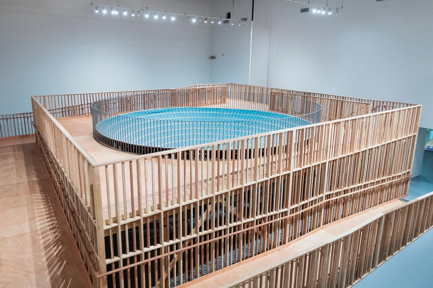 Installation view of Paul Pfeiffer MOCA exhibit featuring a large wooden structure enclosing a circular, blue-tiled arena designed by Sparano + Mooney Architecture