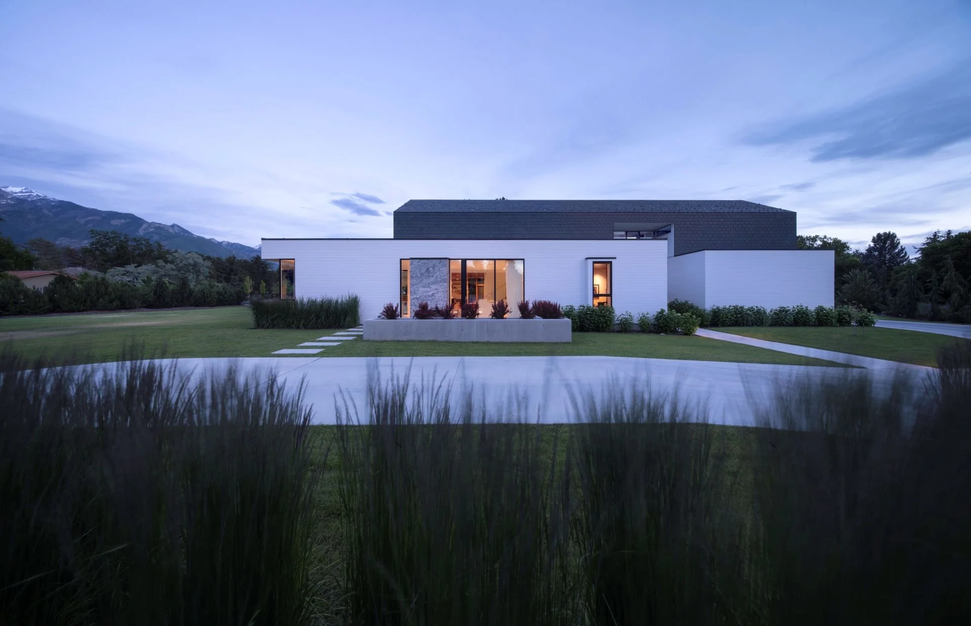 Glowing entrance elevation to Utah modern farmhouse designed by Sparano + Mooney Architecture.
