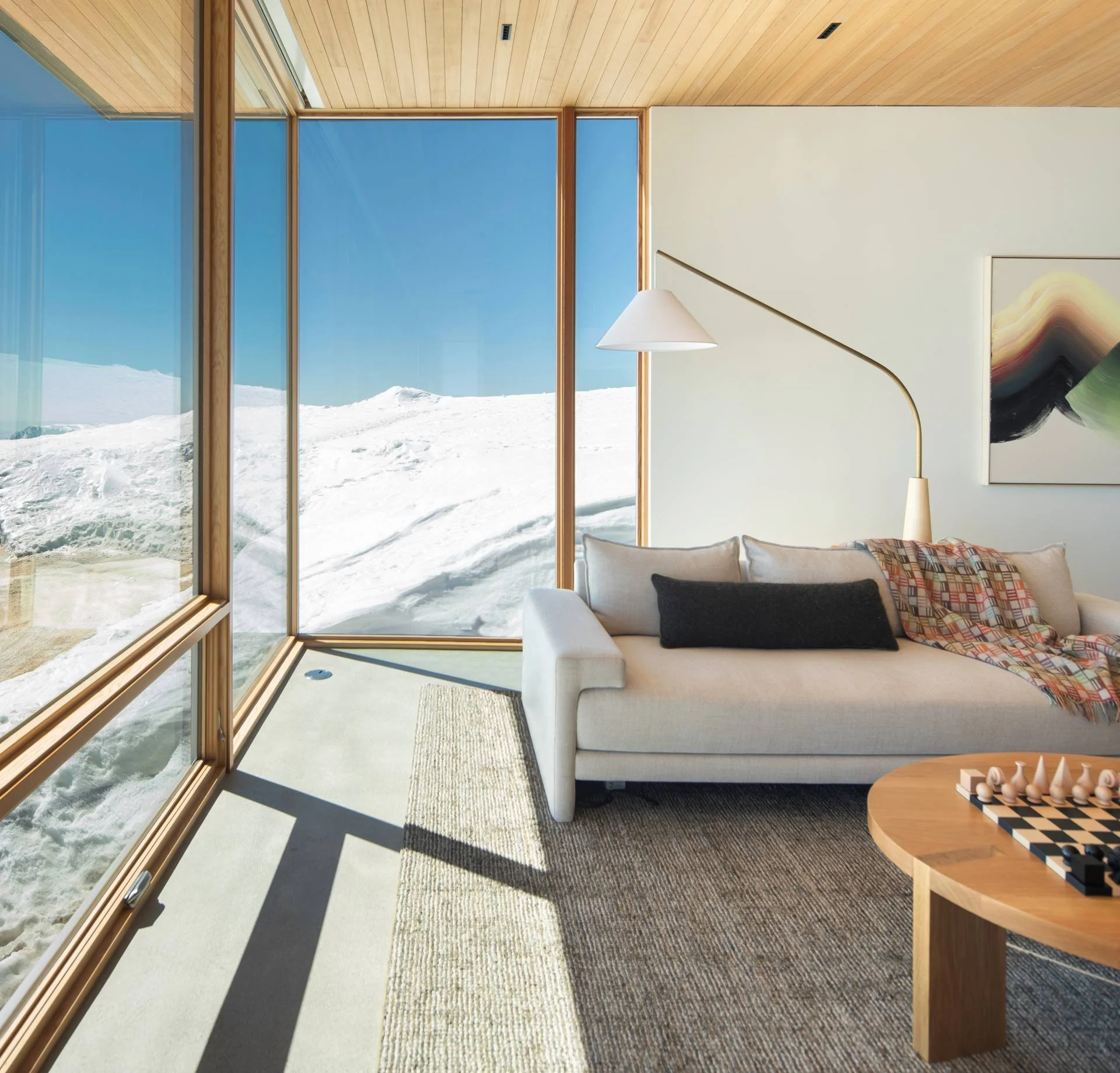 Modern living space designed by Sparano + Mooney Architecture with expansive views of snowy mountains and blue skies in Sun Valley