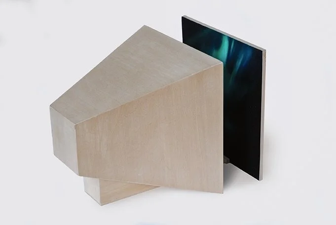 Modern wooden desk with a minimalist design, light wood finish, and a sleek black monitor.