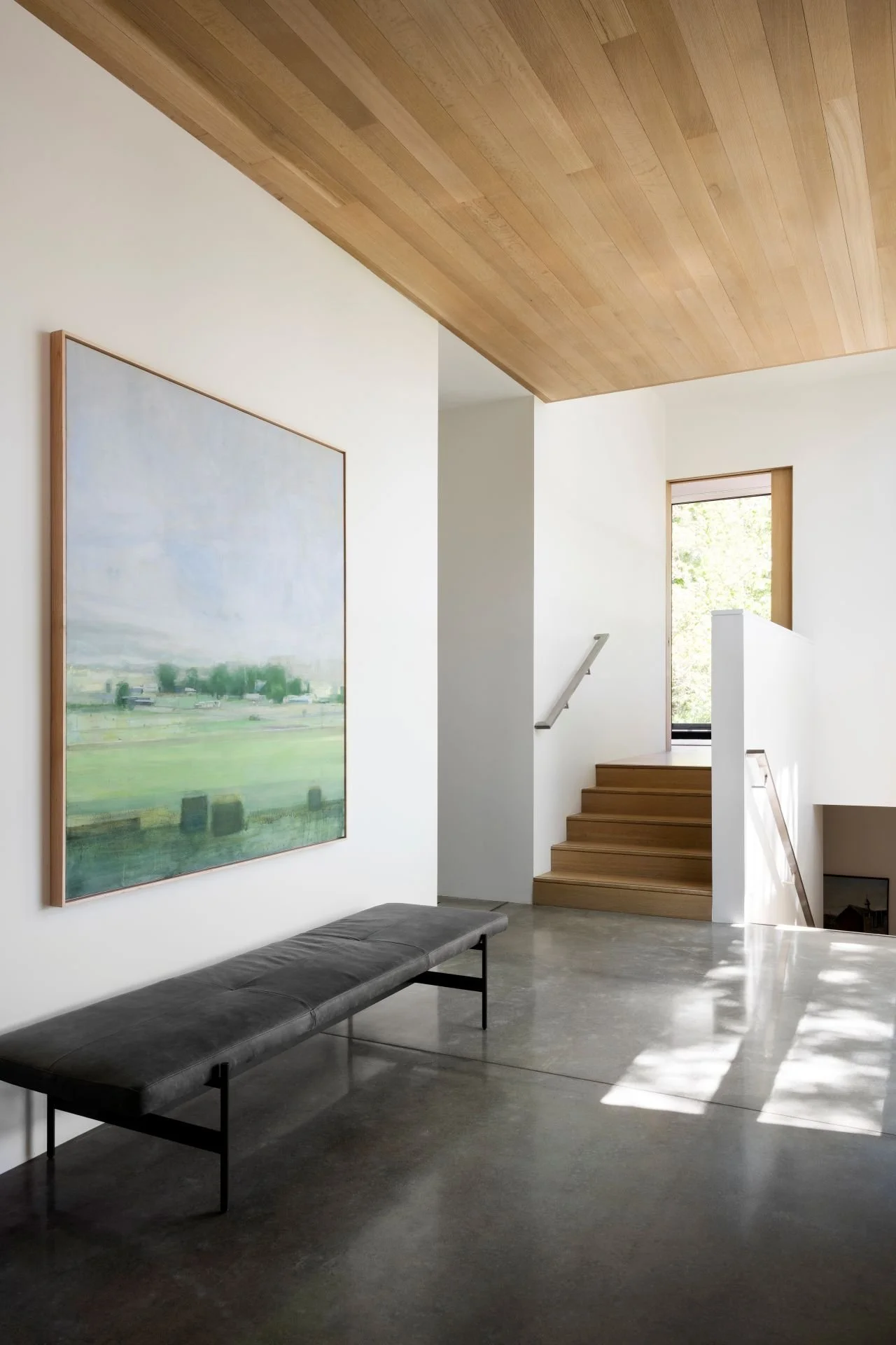 Large modern art in bright hall with wood ceilings and concrete floor designed by Sparano + Mooney Architecture.