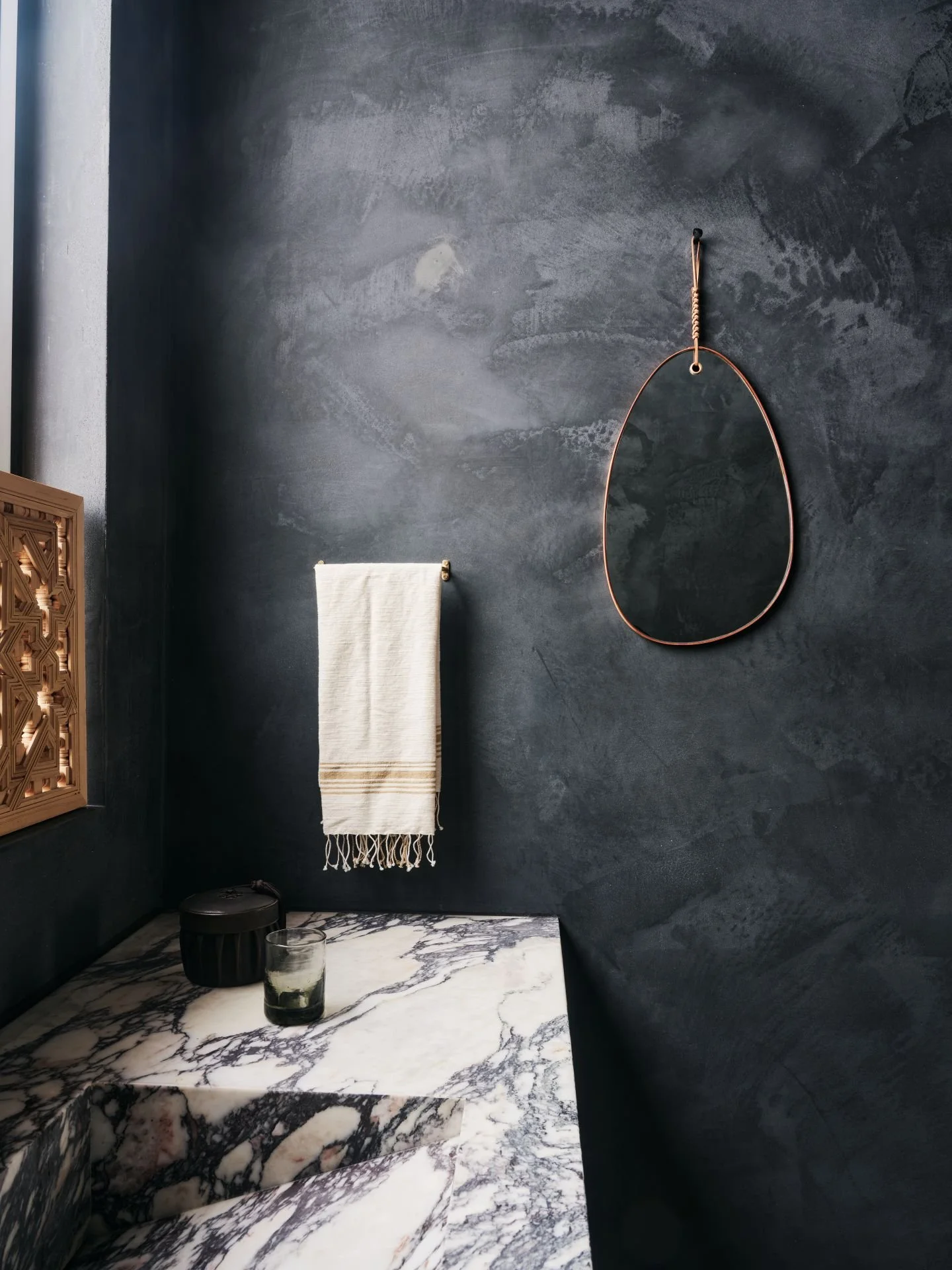 Park City Nest Residence bathroom with dark walls and white marble counter designed by Sparano + Mooney Architecture