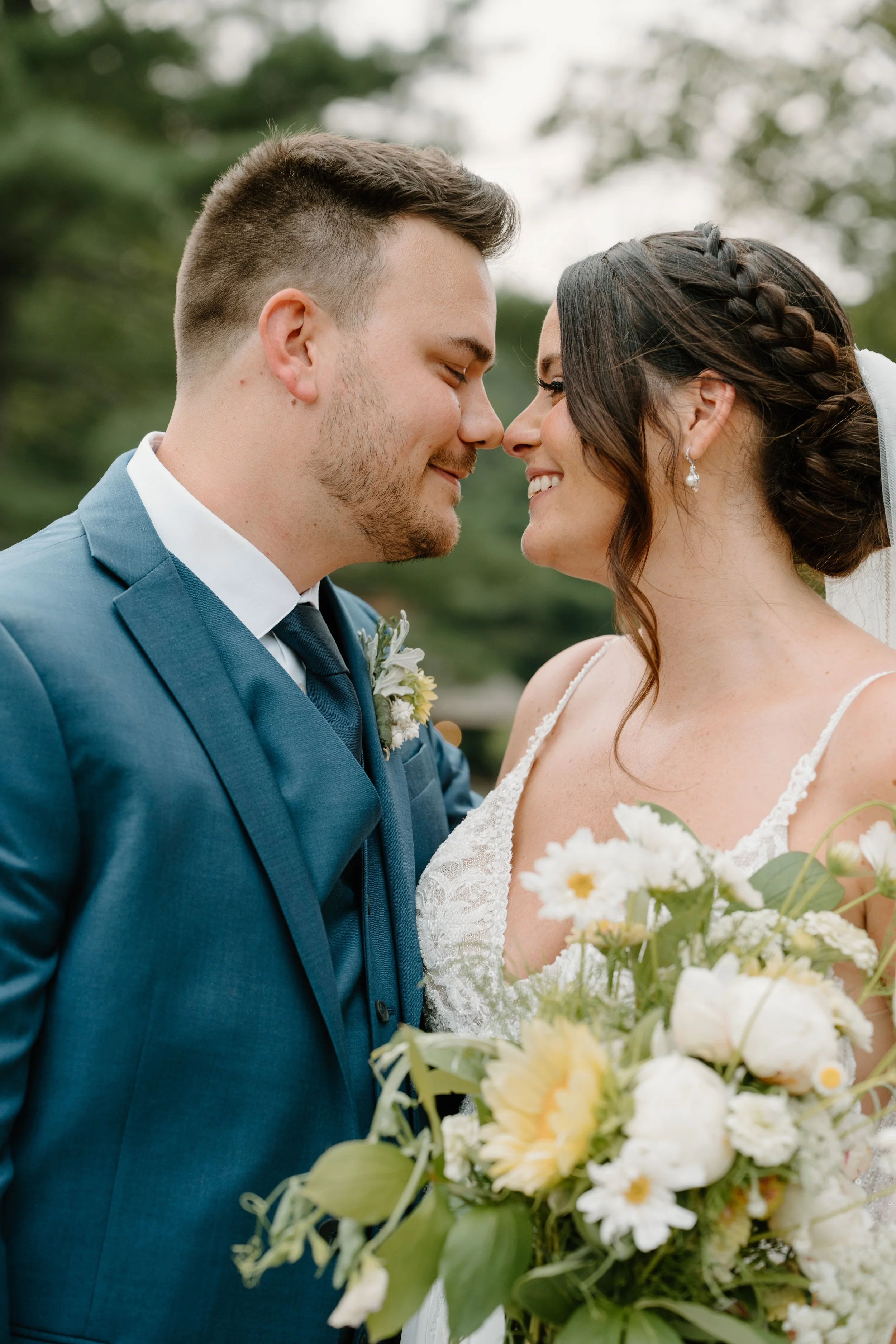 A bride and groom stand close together, smiling with foreheads touching during a wedding at the Aqua Turf Club in Connecticut. 