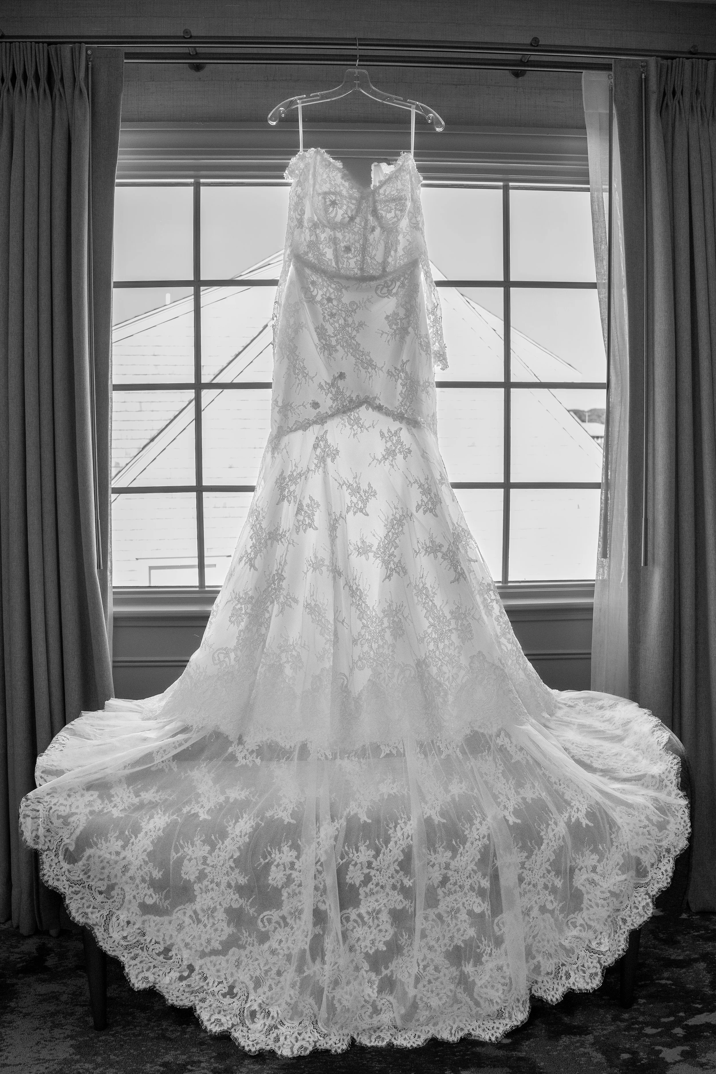 Wedding dress hanging in front of a window during a wedding at Red Jacket Resort in Cape Cod. 