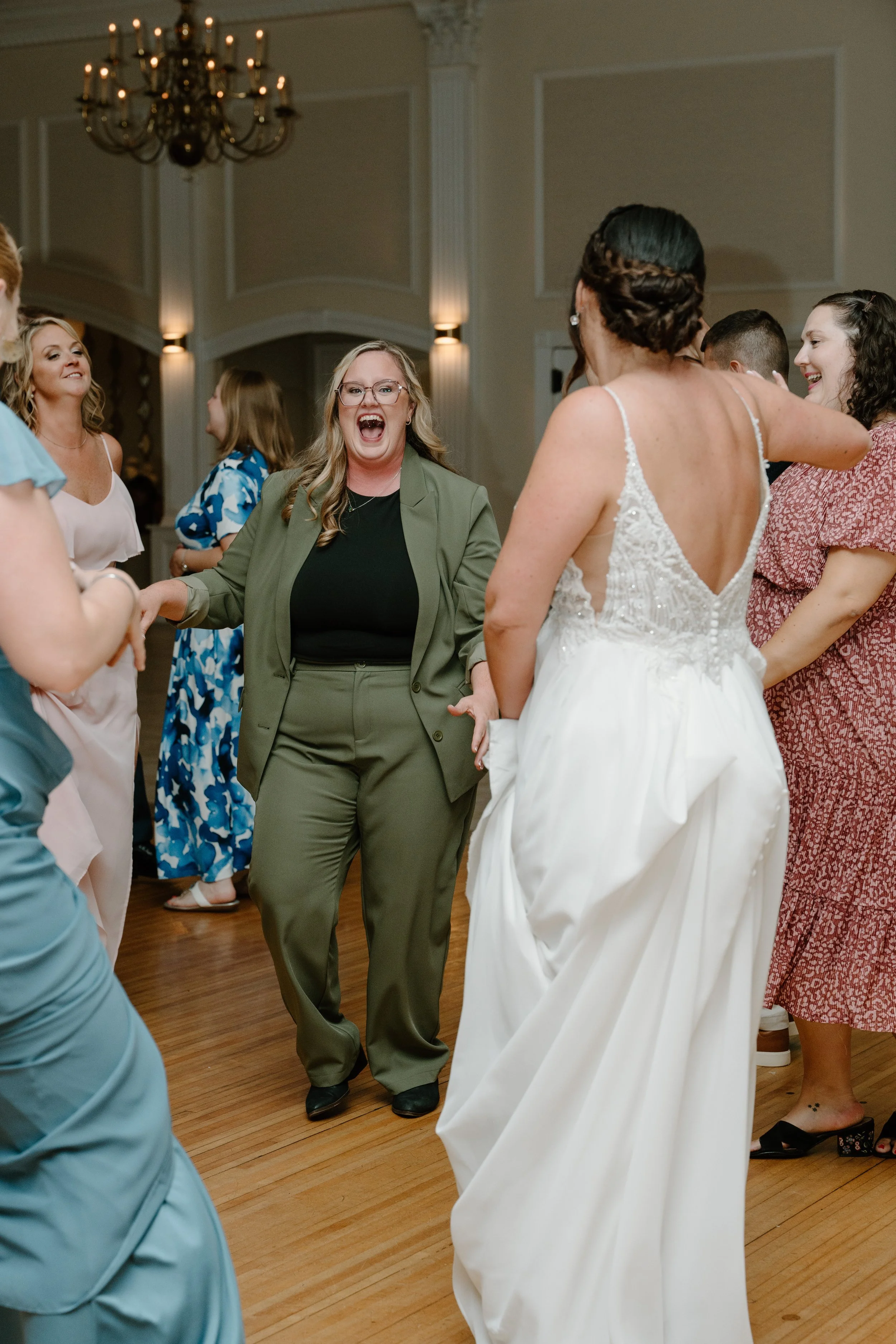 Group of women dancing and celebrating at a wedding reception, with one woman in a white wedding dress during a wedding at the Aqua Turf Club in Connecticut. 
