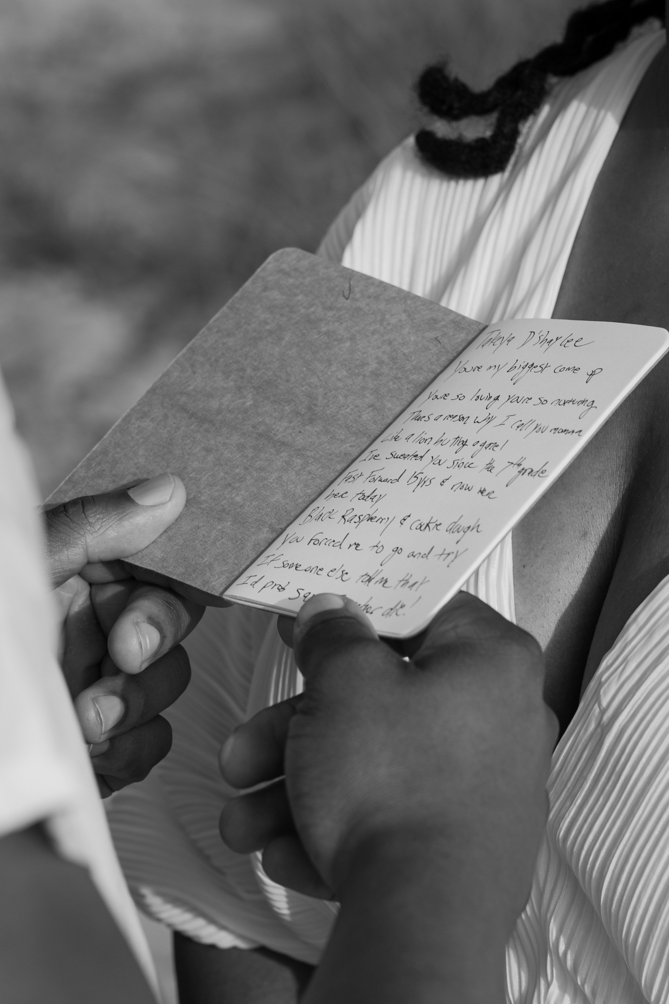 Person holding a small notebook with handwritten note at an elopement at Second Beach in Rhode Island. 