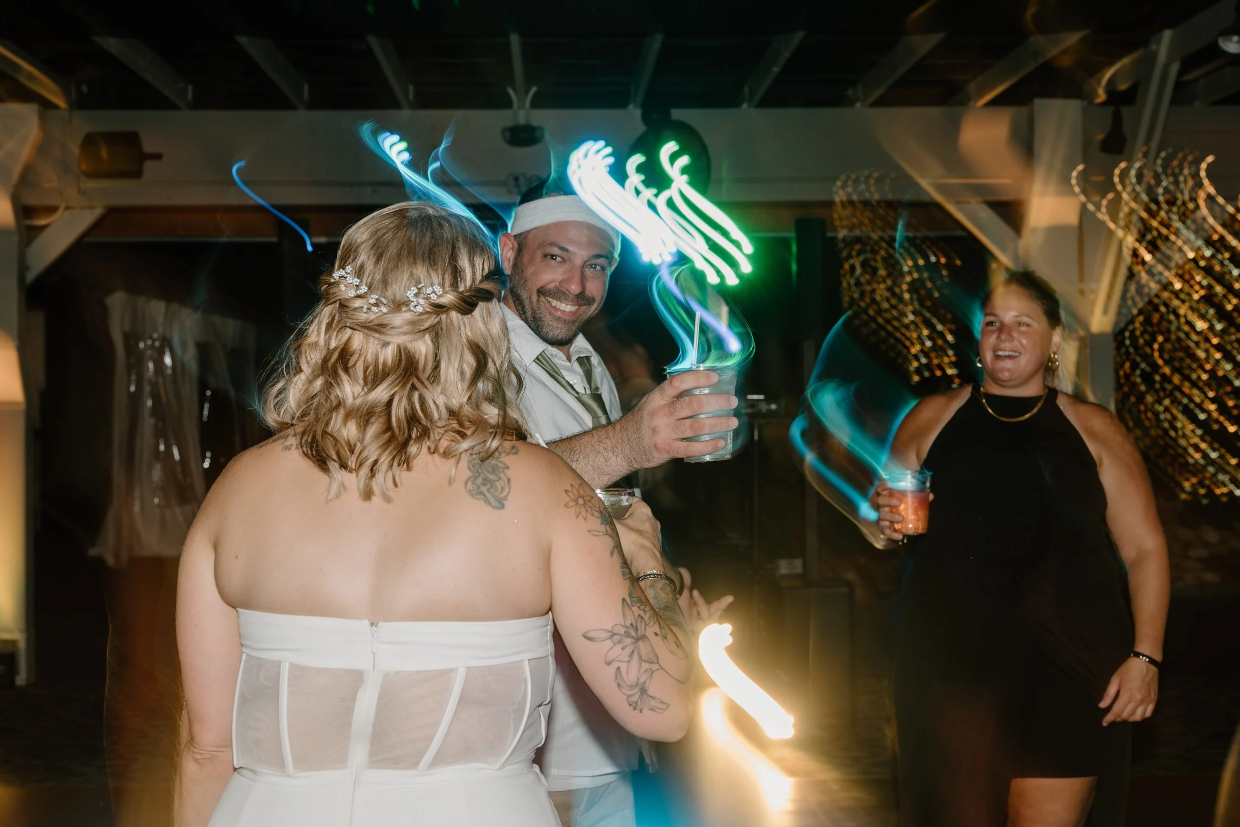 People dancing and having fun at a party with colorful light streaks and a joyful atmosphere for a wedding at Tunxis Country Club in Connecticut. 