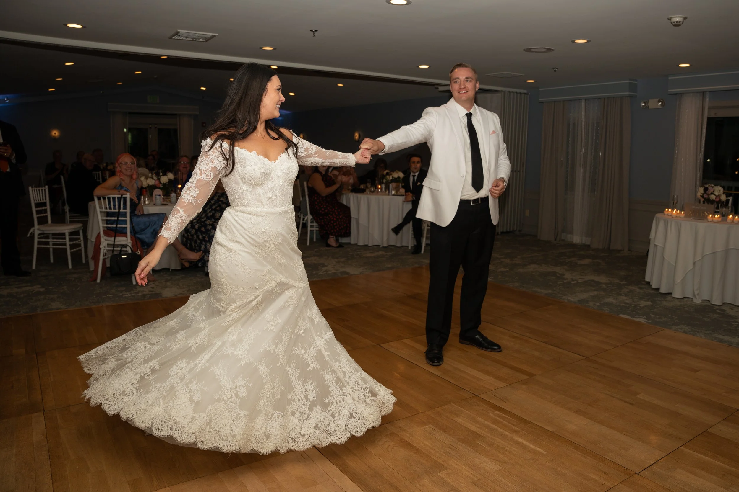 Bride and groom dancing at their wedding reception, with guests watching in the background during a wedding at Red Jacket Resort in Cape Cod. 