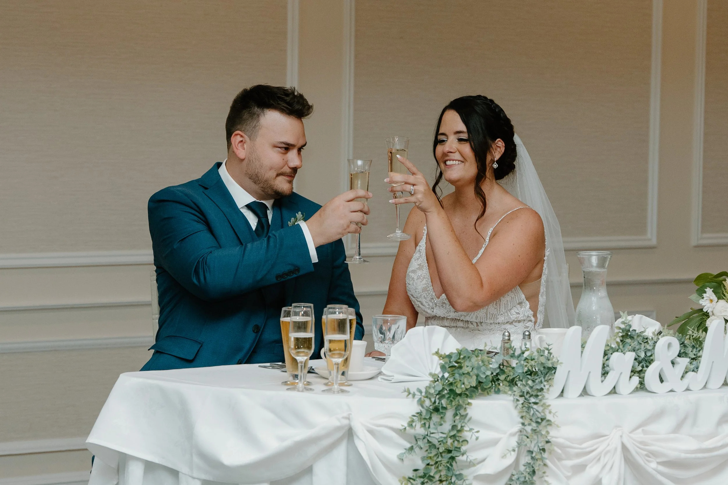 Bride and groom toasting with champagne during wedding celebration at decorated table during a wedding at the Aqua Turf Club in Connecticut. 