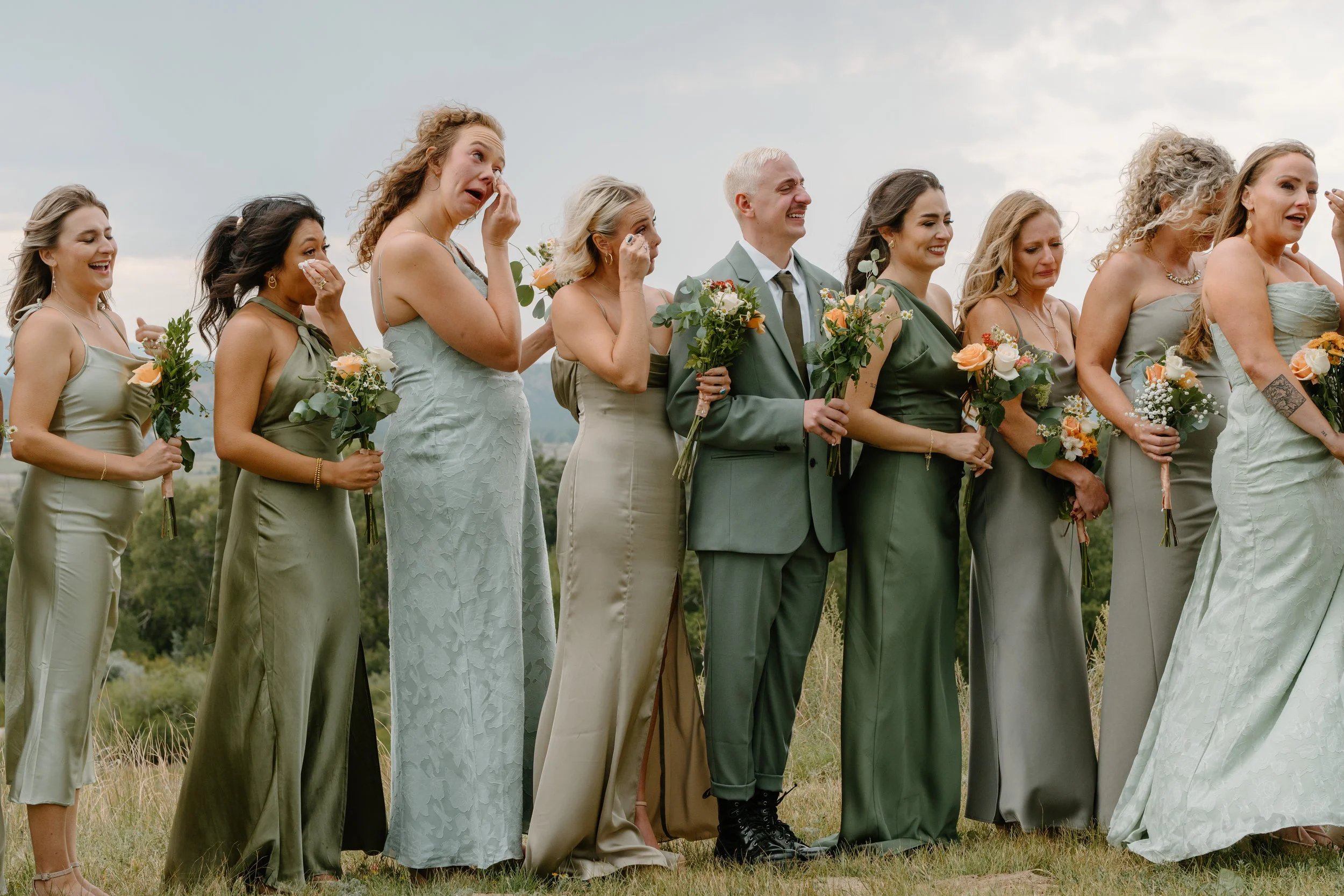A wedding party standing outdoors on grass at a wedding at Everett Ranch in Salida, Colorado.