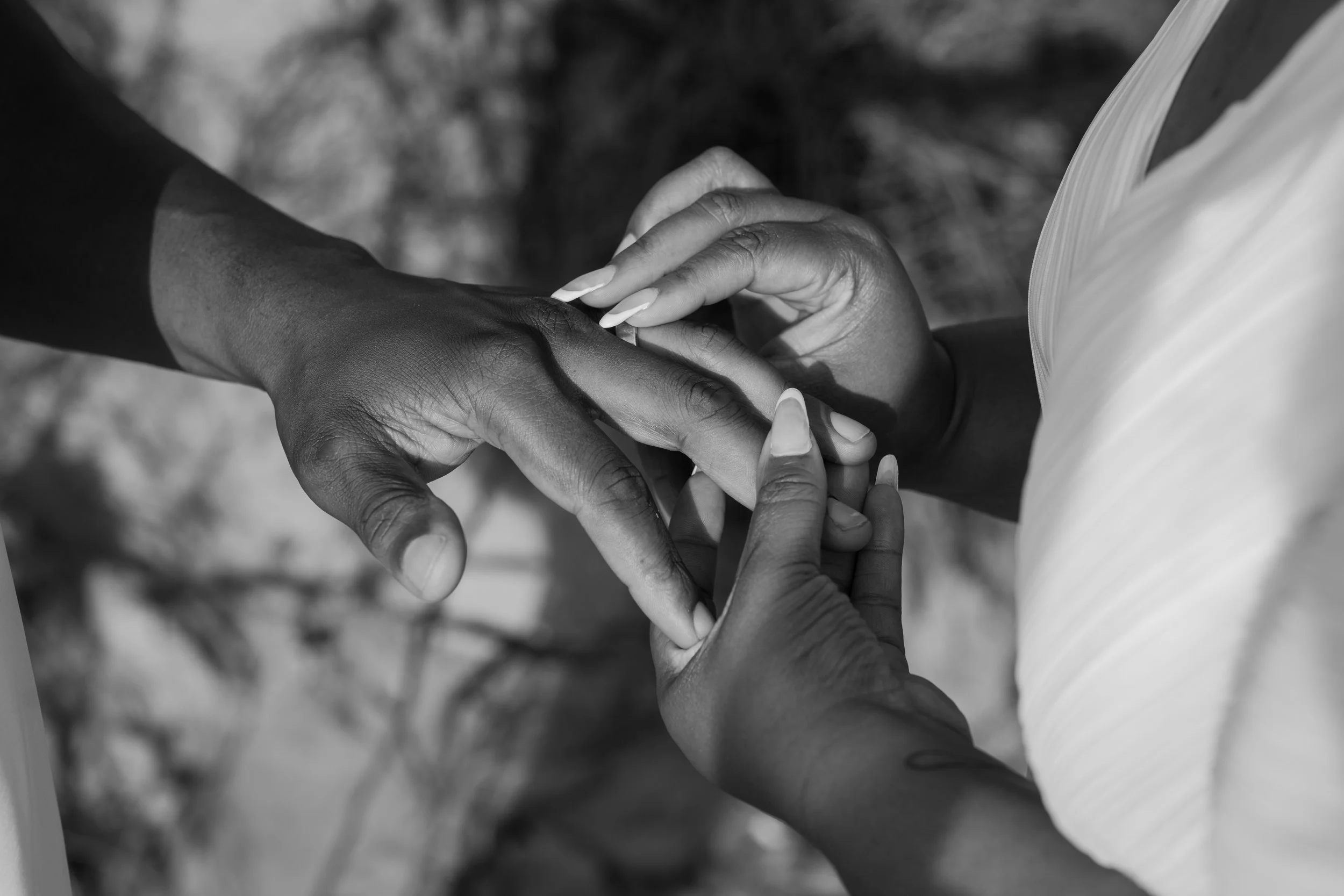 Two people holding hands and exchanging rings at an elopement at Second Beach in Rhode Island. 