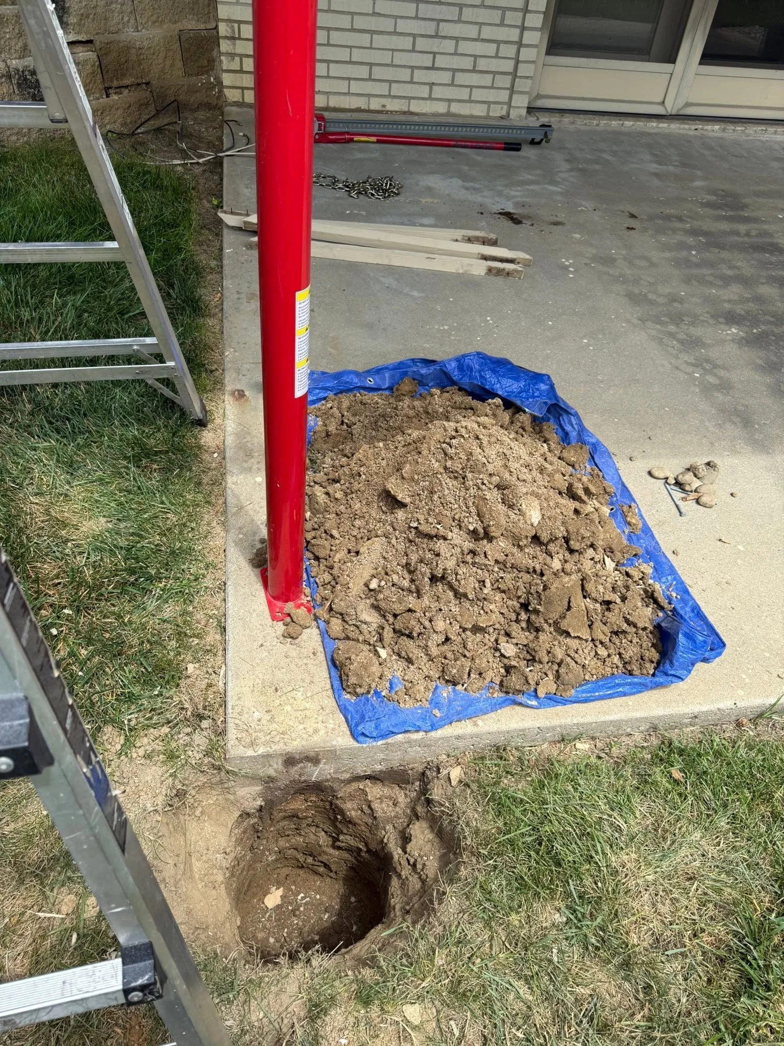 Old footing dug out through the patio before the new post goes in