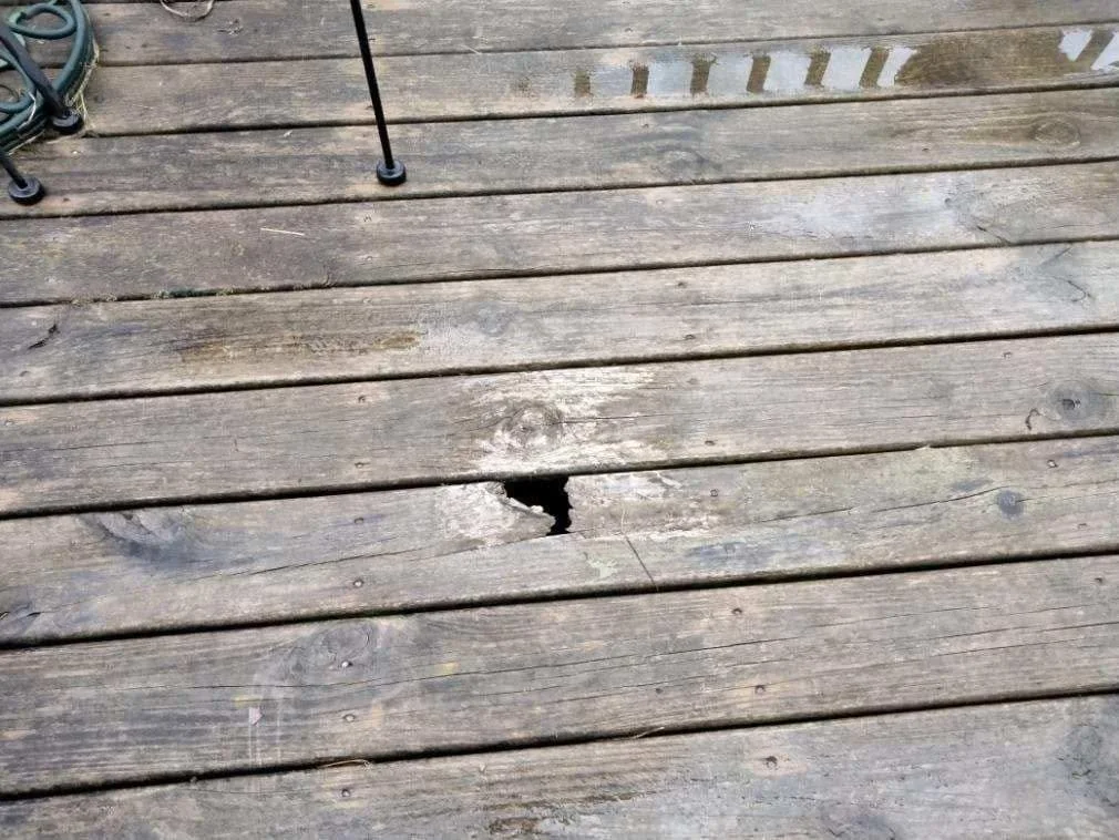 Deck boards before — weathered and gray