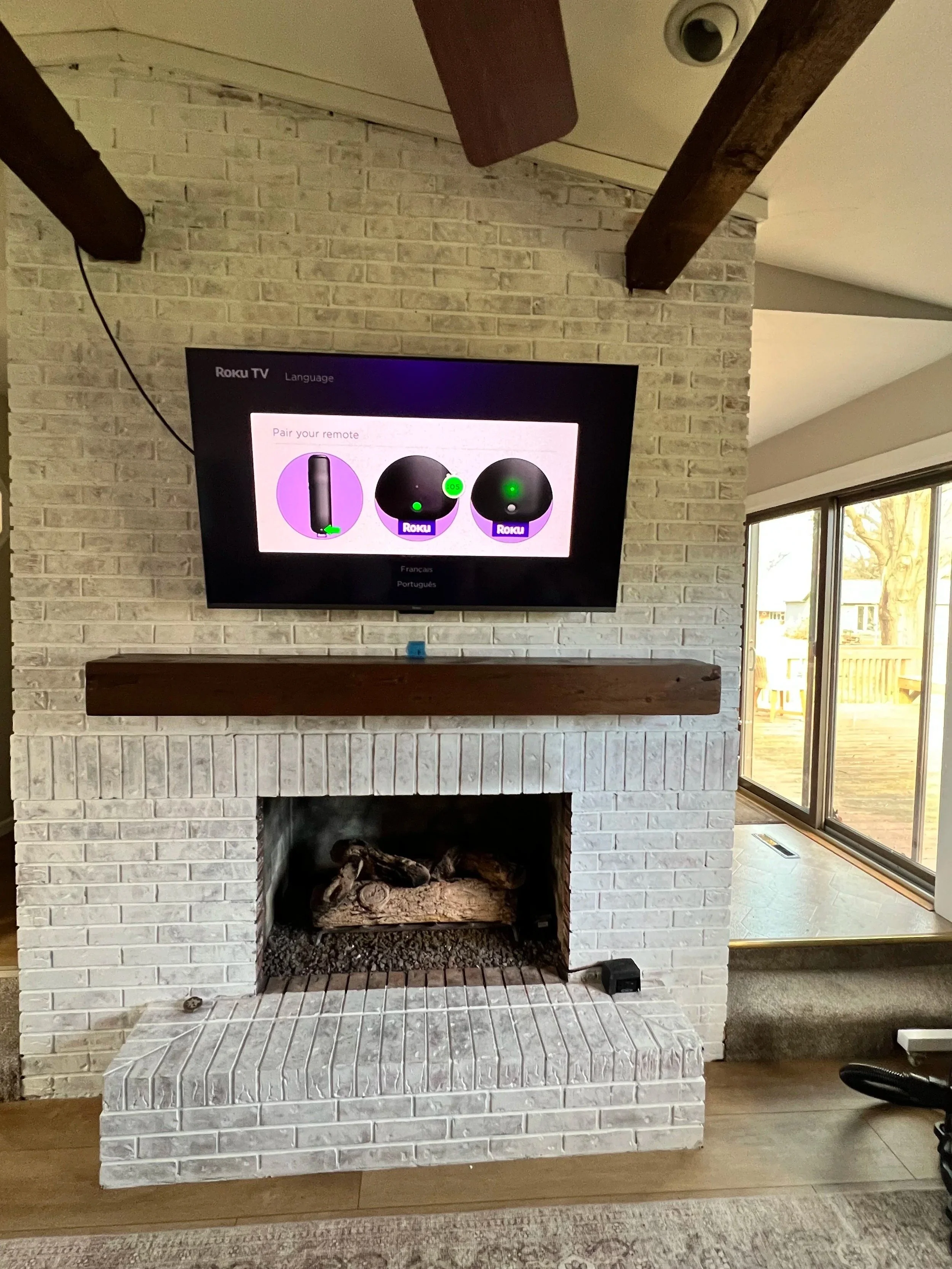 TV and mantle mounted on a living room wall