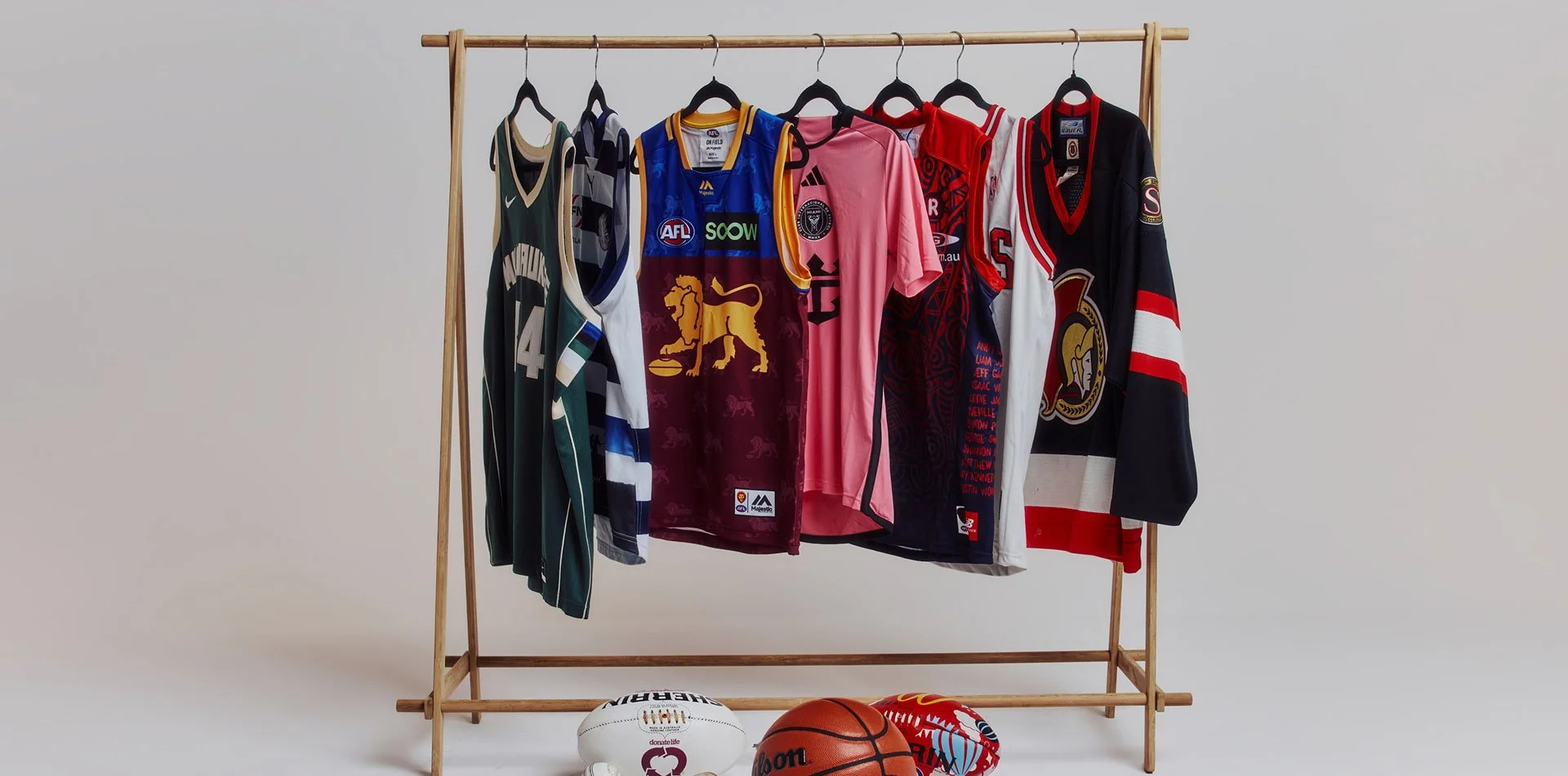 Assorted professional sports jerseys and balls representing AFL, NRL, NBA, rugby, and baseball – symbolising Prince Sports & Entertainment’s work across major codes and athlete brands