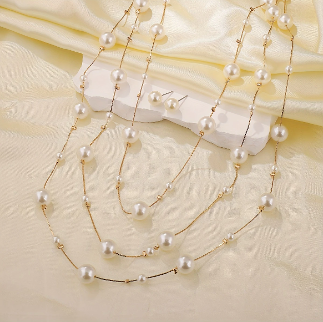 Drape yourself in elegance with Mozzimo Jewelry’s long triple-layer faux pearl necklace set — effortless glamor with modern layering appeal.