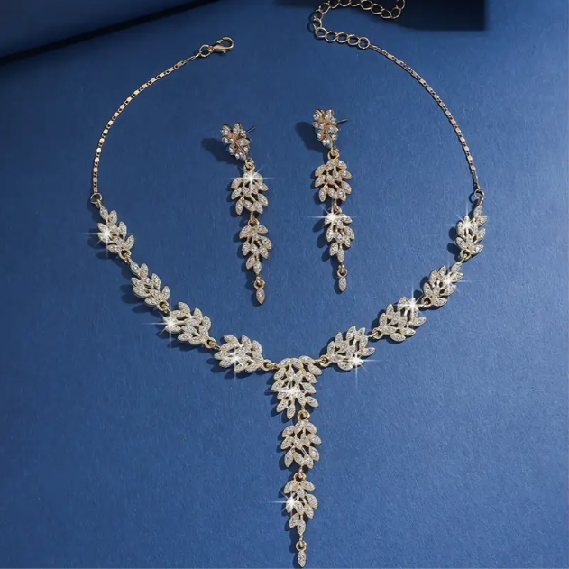 Shine with the 3 Piece Gold-Plated Sparkly Rhinestone Leaf Drop Earrings and Necklace Set, a glamorous and elegant accessory—available now at Mozzimo Jewelry.