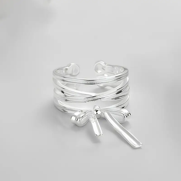 Delicate and elegant, our Sterling Silver Wrapped Ribbon Bow Ring adds a feminine touch to any look with its adjustable fit.