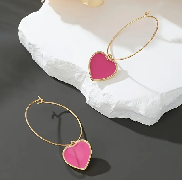 Add a pop of color with the Gold Plated Thin Hooks Hoop Pink Heart Earrings from Mozzimo Jewelry, offering a chic and playful design perfect for any occasion.