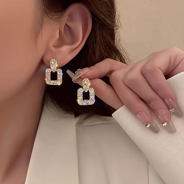 Shine in style with these Mini Golden Silver Rhinestone Encrusted Geometric Square Dangle Earrings, featuring a dazzling square design with shimmering rhinestones.