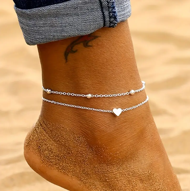 Discover our Sterling Silver Double Layer Heart and Ball Anklet, a trending piece in minimalist, beach, and boho jewelry—available now at Mozzimo Jewelry.