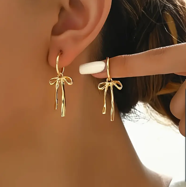 Discover gold-plated darling bow-tie mini hoop tassel earrings at Mozzimo Jewelry—elevate your style with this chic and playful accessory.