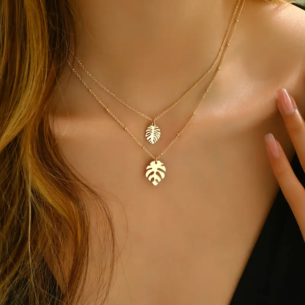 Embrace tropical vibes with our Gold Plated Double Layer Tropical Leaf Fine Necklace, a dainty yet bold layered piece perfect for elevating any look.