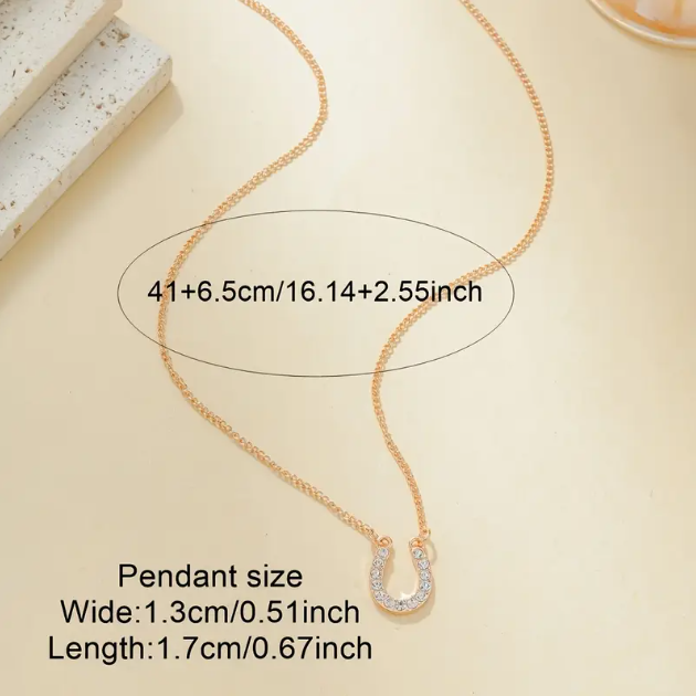 Add a touch of luck and luxury with the Gold Plated Mini White Gemstone Encrusted Horseshoe Pendant Charm Necklace from Mozzimo Jewelry.