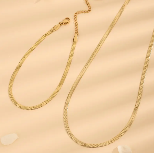 Upgrade your style with this Men's 2 Piece Gold Plated Flat Chain Necklace and Bracelet Set, a sleek and polished addition to any outfit.