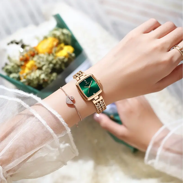 Timeless elegance meets modern sophistication with this Gold Plated Square Emerald Green Quartz Chevron Chain Watch.