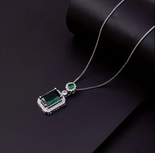 Add a touch of luxury to your collection with this Sterling Silver Rhinestone Encrusted Rectangular Emerald Green Gemstone Chain Necklace.