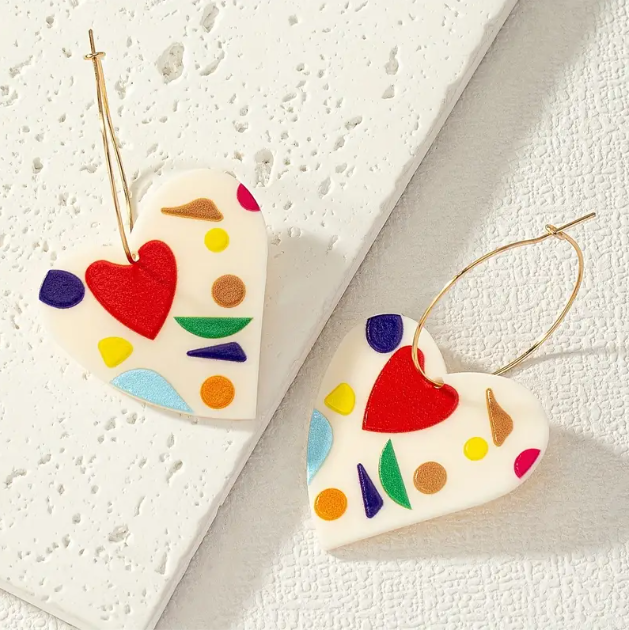 Add a modern touch to your style with Mozzimo Jewelry's Charming Gold Wire Acrylic Geometric Heart Dangle Earrings, a chic and trendy accessory. Shop now!