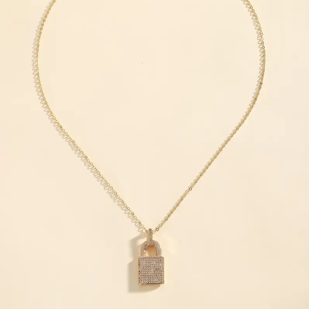 Explore Mozzimo Jewelry’s Gold Plated Rhinestone Encrusted Lock Pendant Charm Necklace—a dazzling gold statement piece with a lock charm—available now at www.mozzimojewelry.com.