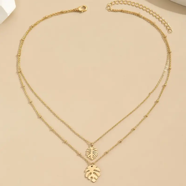 Embrace tropical vibes with our Gold Plated Double Layer Tropical Leaf Fine Necklace, a dainty yet bold layered piece perfect for elevating any look.