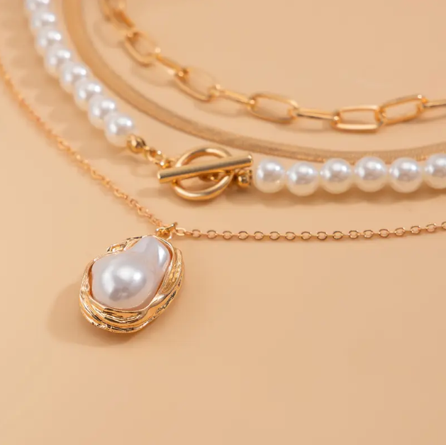 Stunning gold plated triple layer necklace with pearls and bold pendant β the ultimate layering piece for modern elegance and timeless charm.