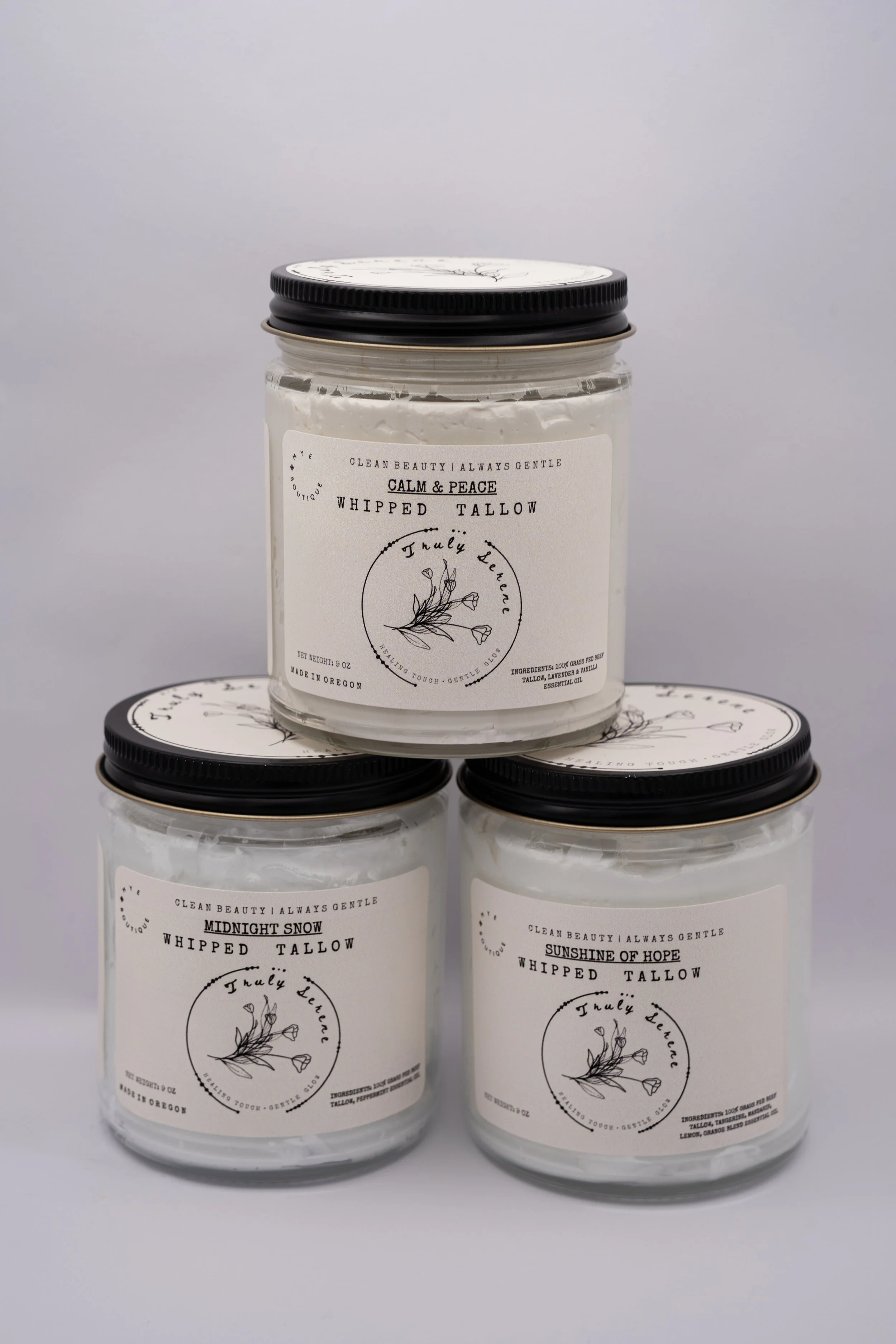 Three jars of whipped tallow candles, with labels reading 'Calm & Peace,' 'Midnight Snow,' and 'Sunshine of Hope,' placed against a light grey background.