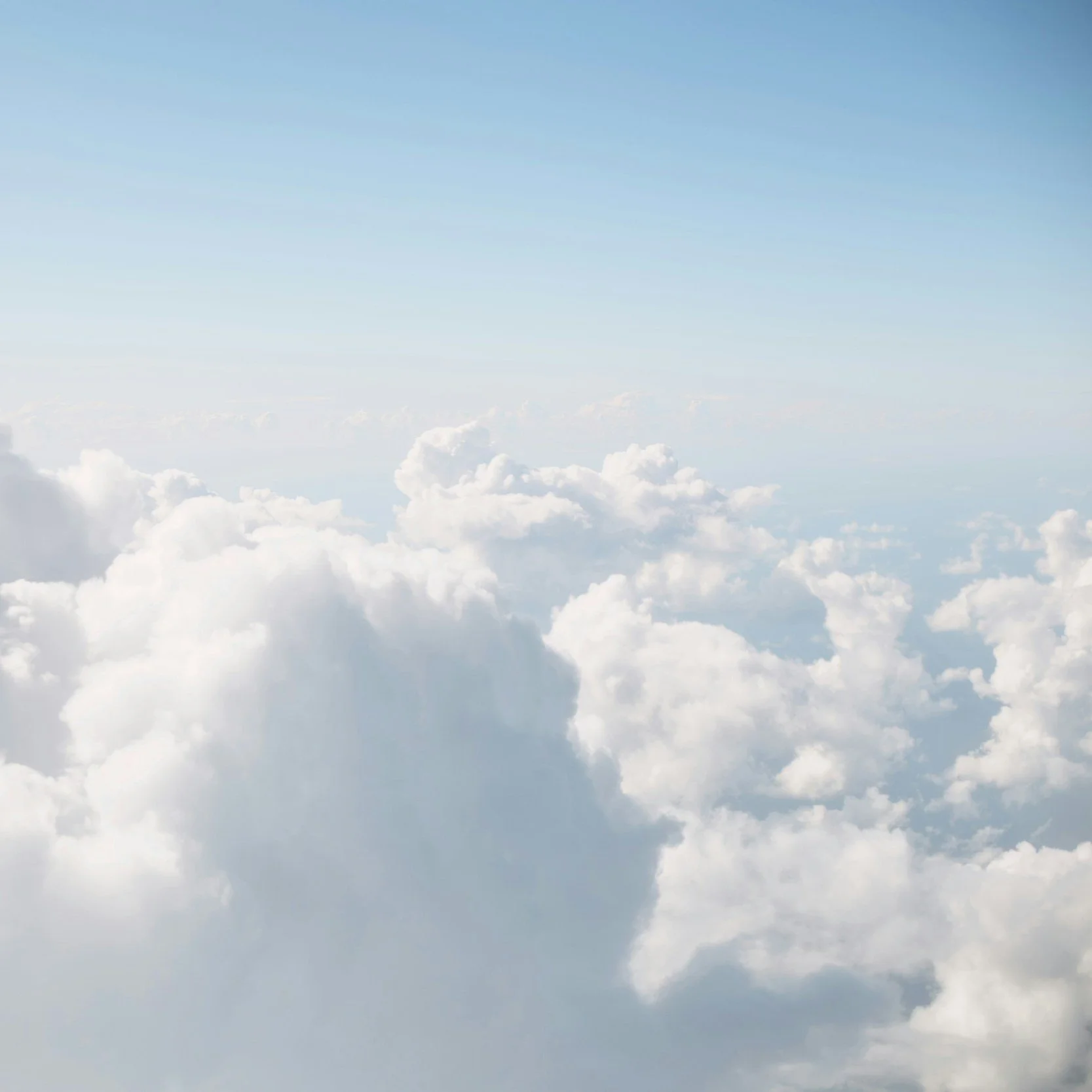 View of fluffy white clouds from above the clouds on a bright day