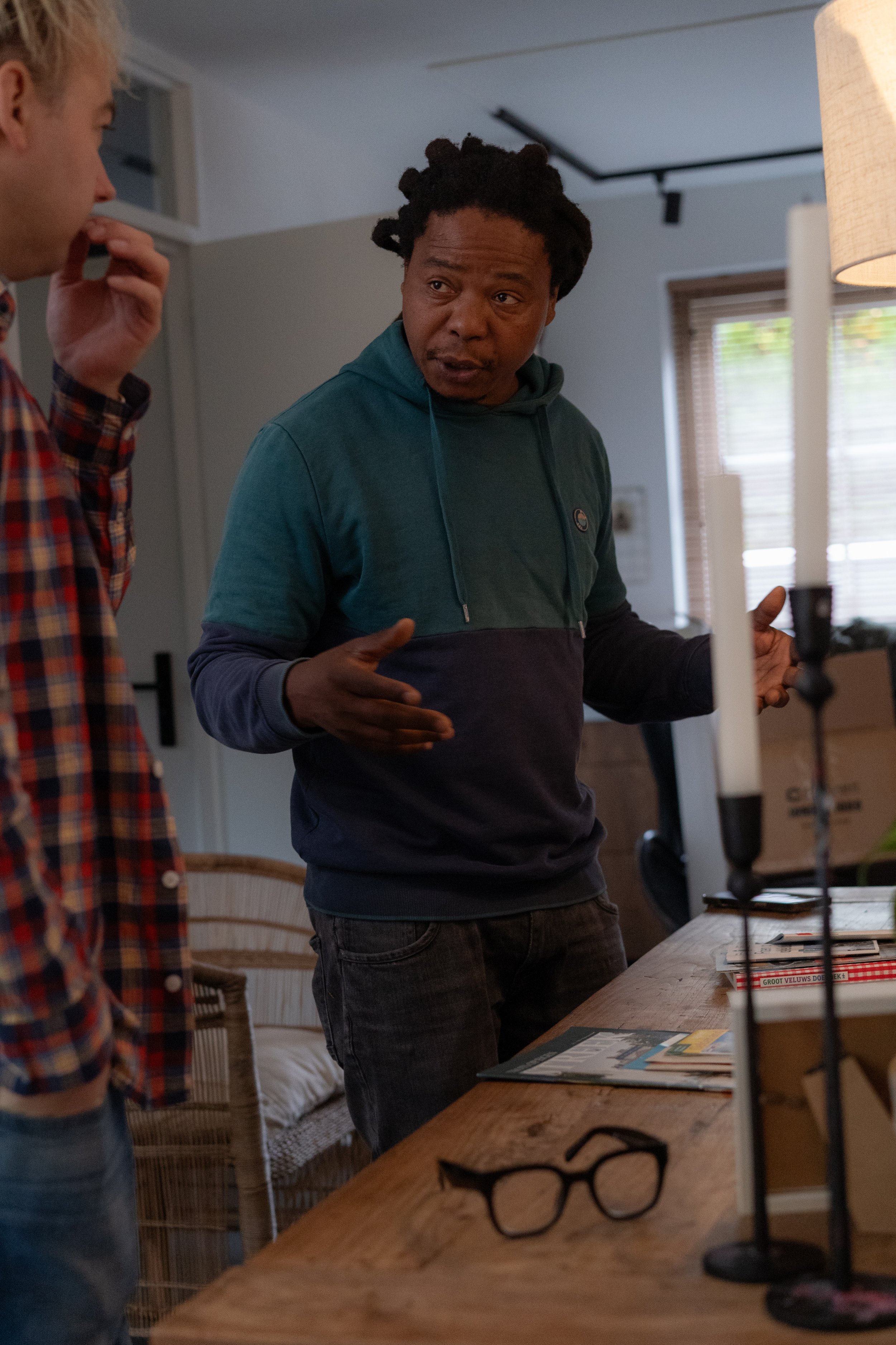 Cinematographer discussing scene and directing actor movement during indoor film shoot