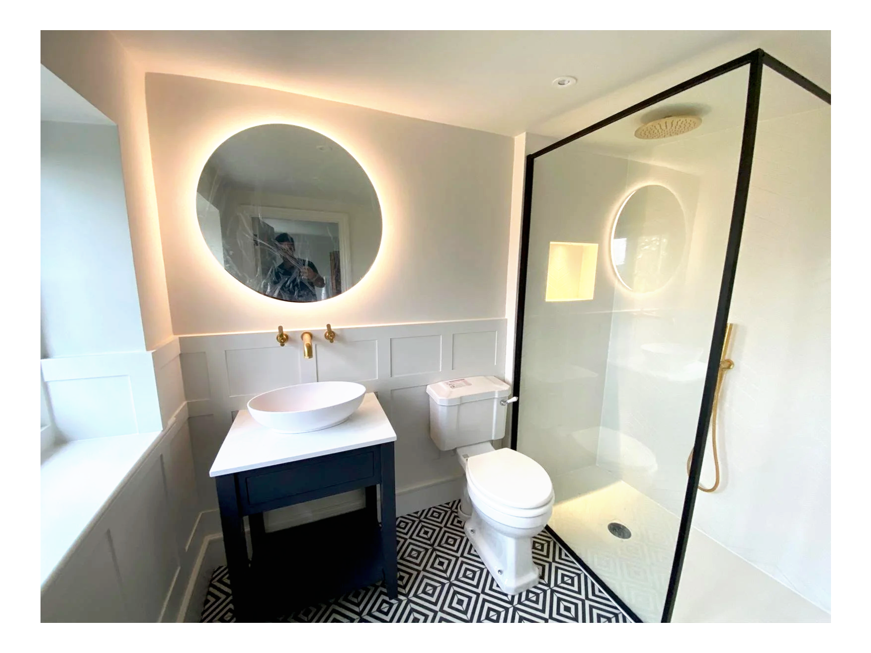 Modern bathroom with a glass shower enclosure, a white vessel sink on a light wood vanity, and a large mirror.