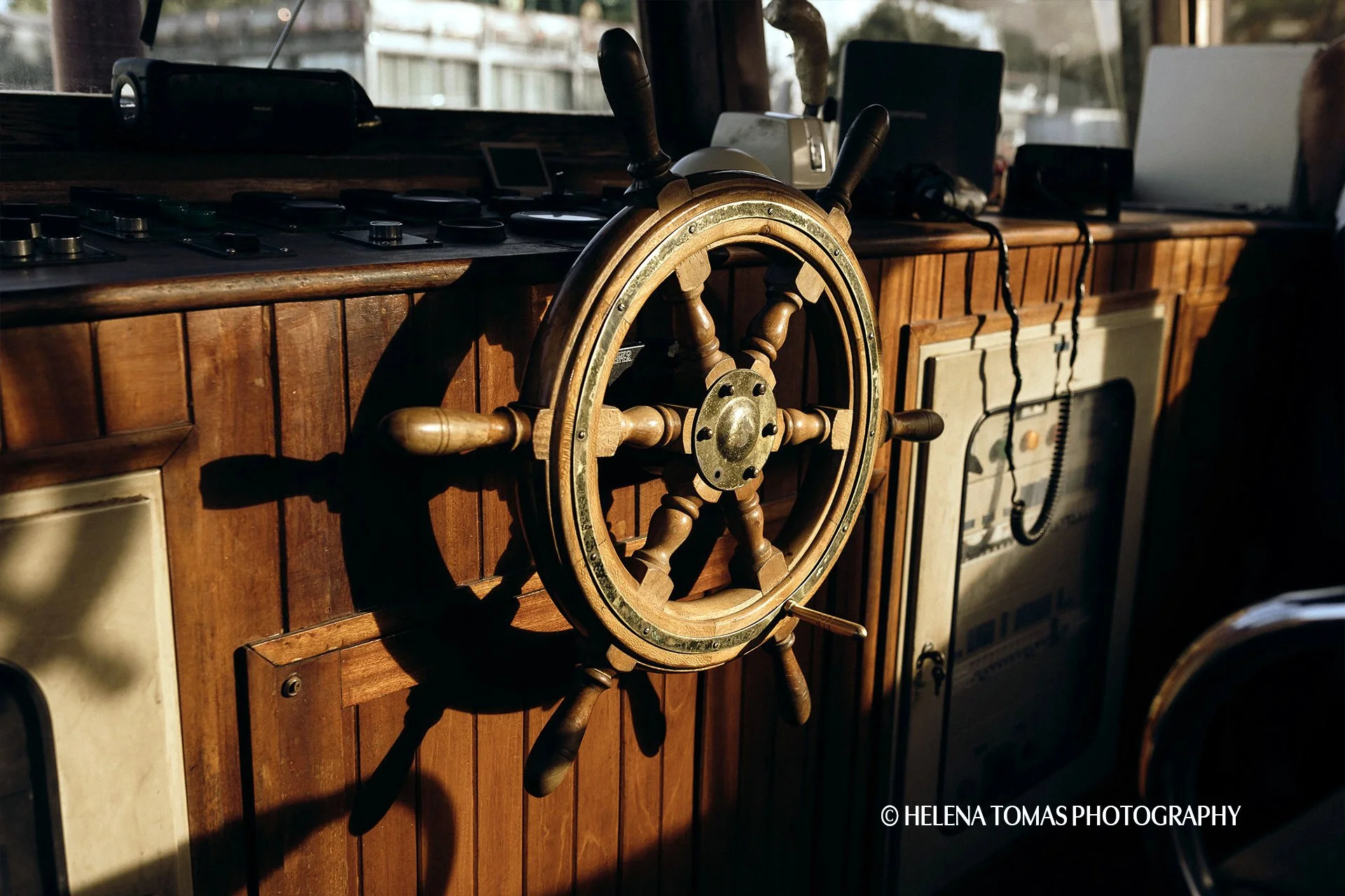 Traditional wooden helm aboard a private Rabelo boat in Porto
