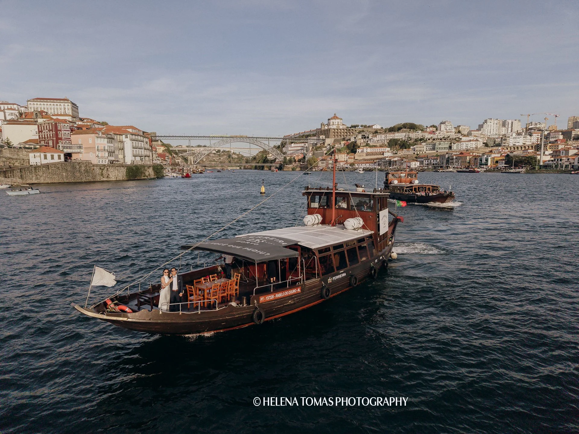 Rabelo boat sailing on the Douro River in front of the Luís I Bridge