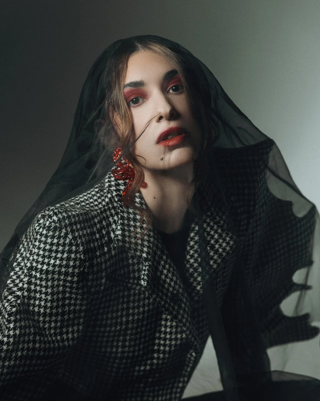 Editorial-Look mit rotem Augen-Make-up und schwarzem Schleier