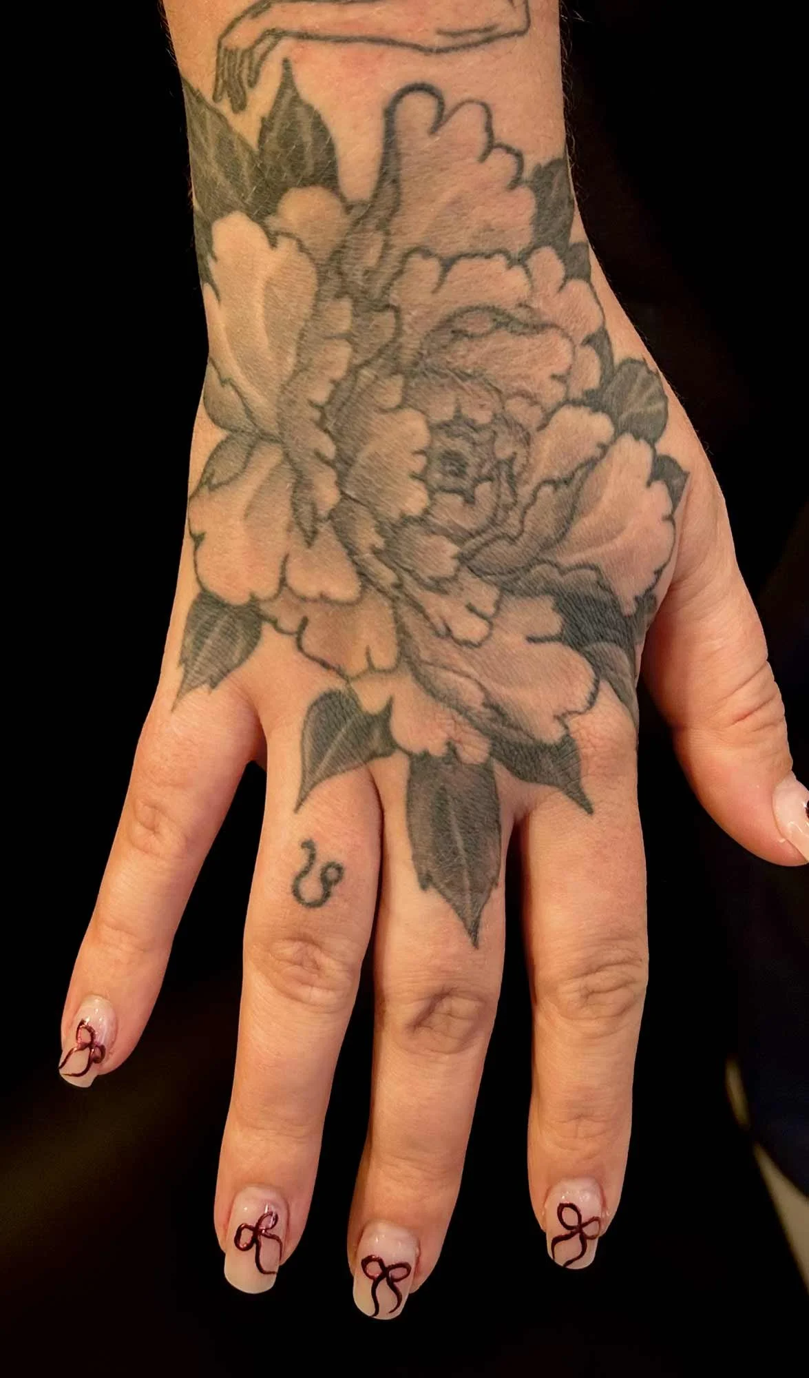 Beautiful Chrysantheum flower tattoo on hand in black and grey from upstate New York.