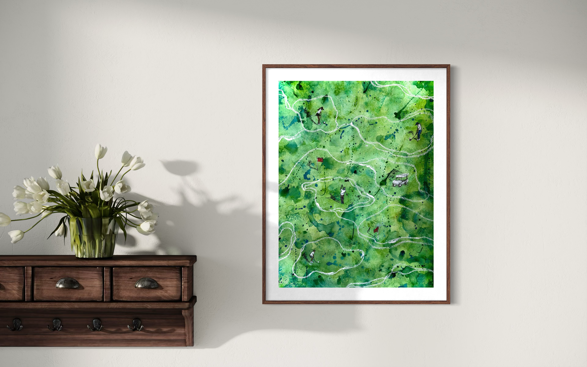Watercolor painting of a golf course map with pathways, trees, and small figures playing golf, framed and hung on a wall.