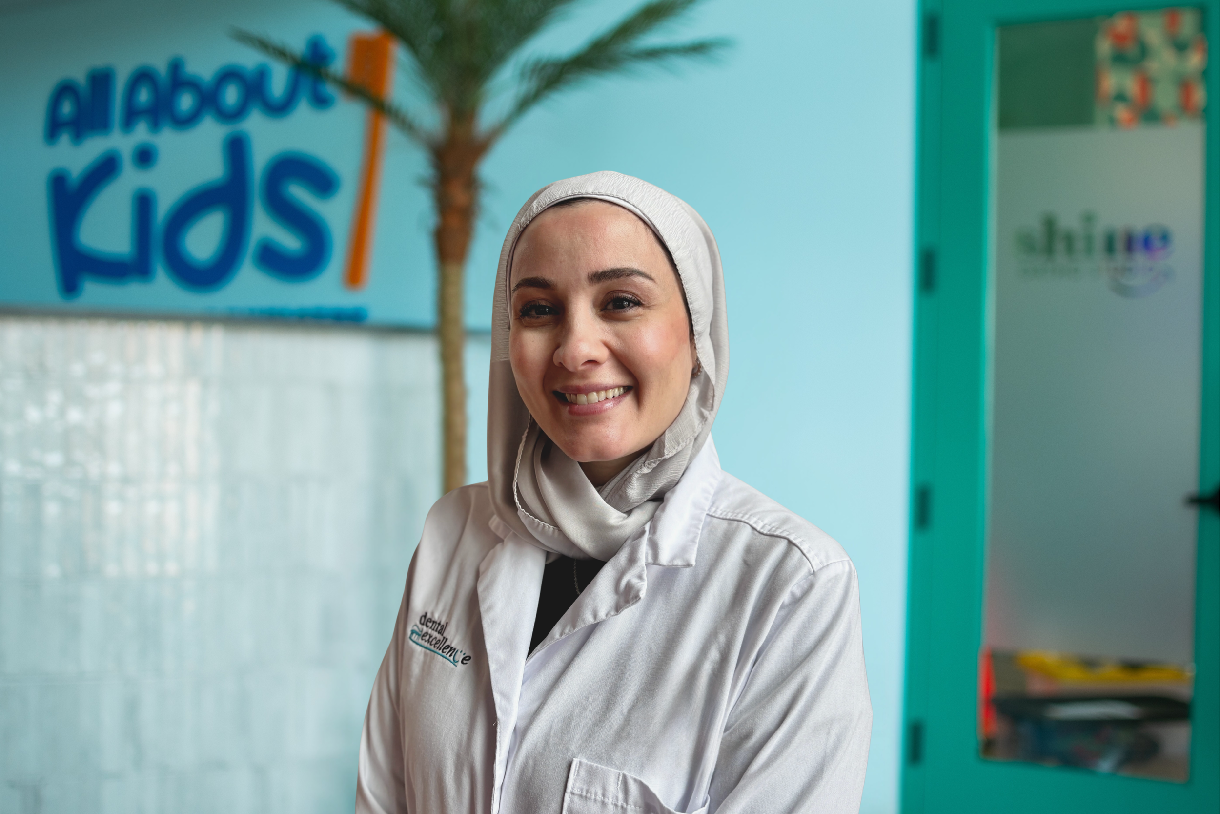 Dr. Sarsour, pediatric dentist at All About Kids Pediatric Dentistry in Napoleon Ohio, smiling in a professional portrait inside the office.