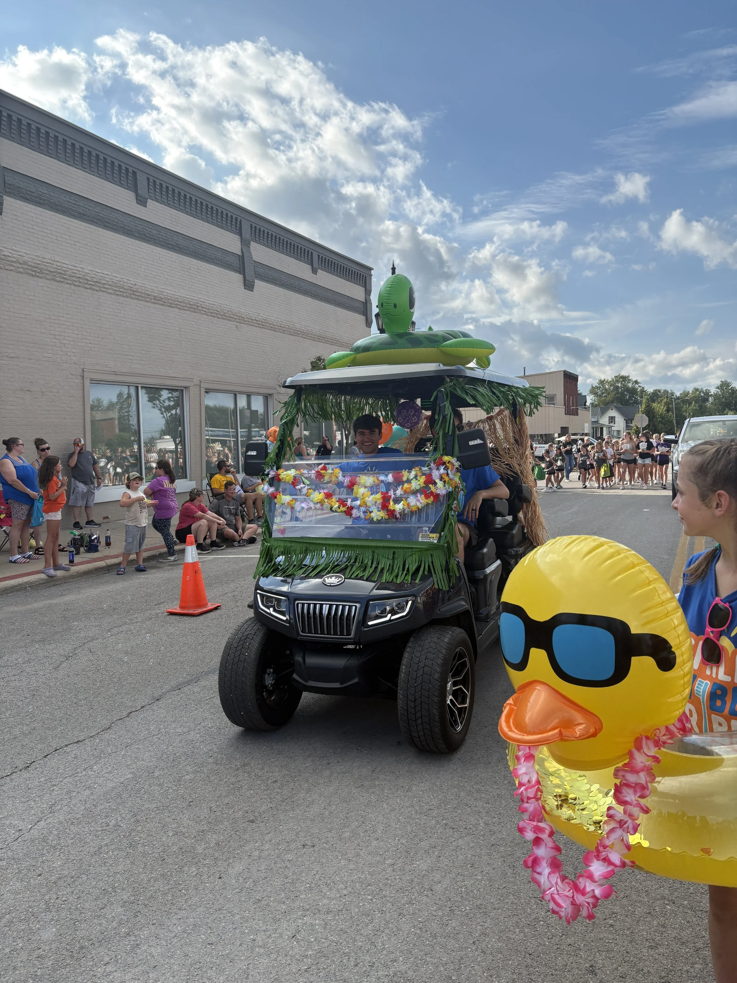 All About Kids Pediatric Dentistry decorated golf cart float with tropical theme rolling down the street during the Henry County Parade in Napoleon.
