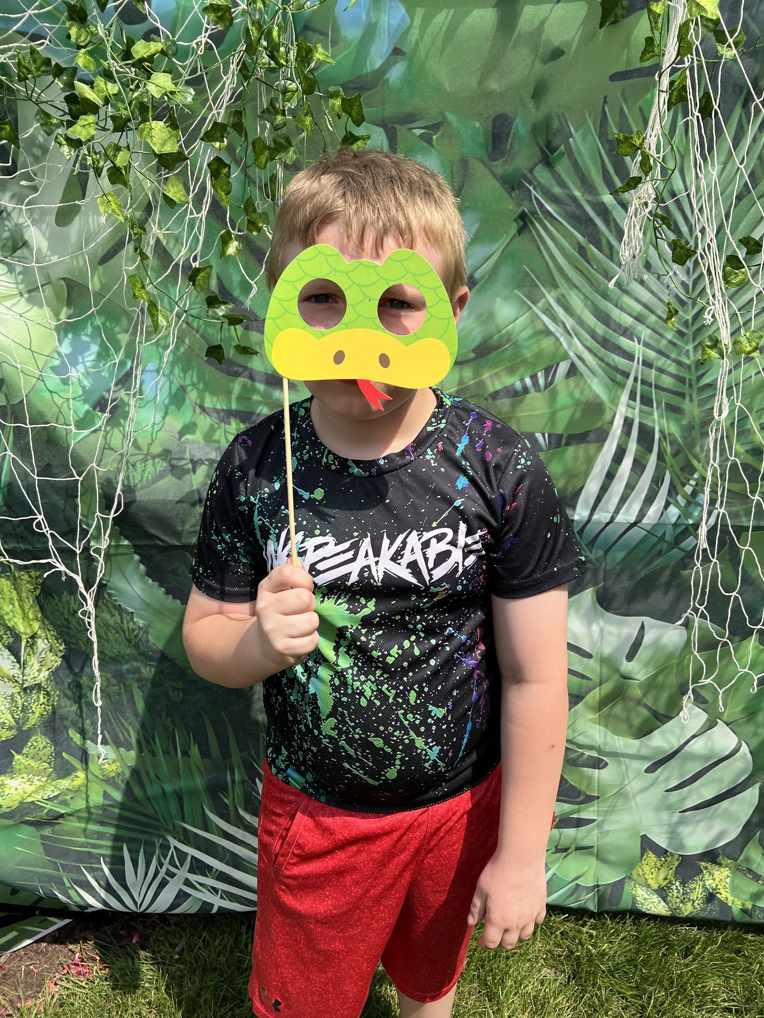 Child smiling while wearing an animal themed mask during All About Kids Pediatric Dentistry Kids’ Day event in Napoleon Ohio.