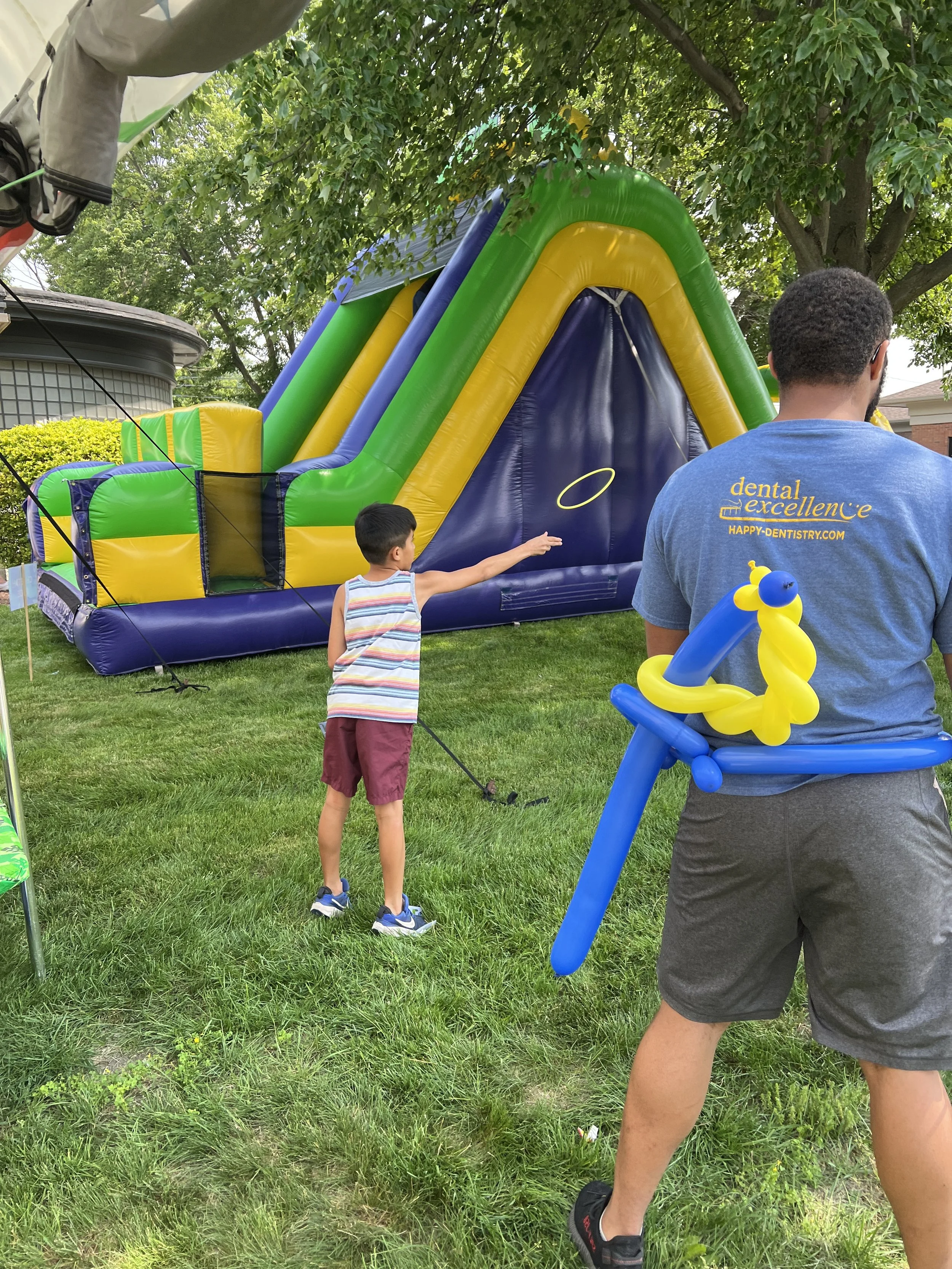 Kids playing outdoor games and enjoying an inflatable at All About Kids Pediatric Dentistry Kids’ Day community event in Napoleon Ohio.