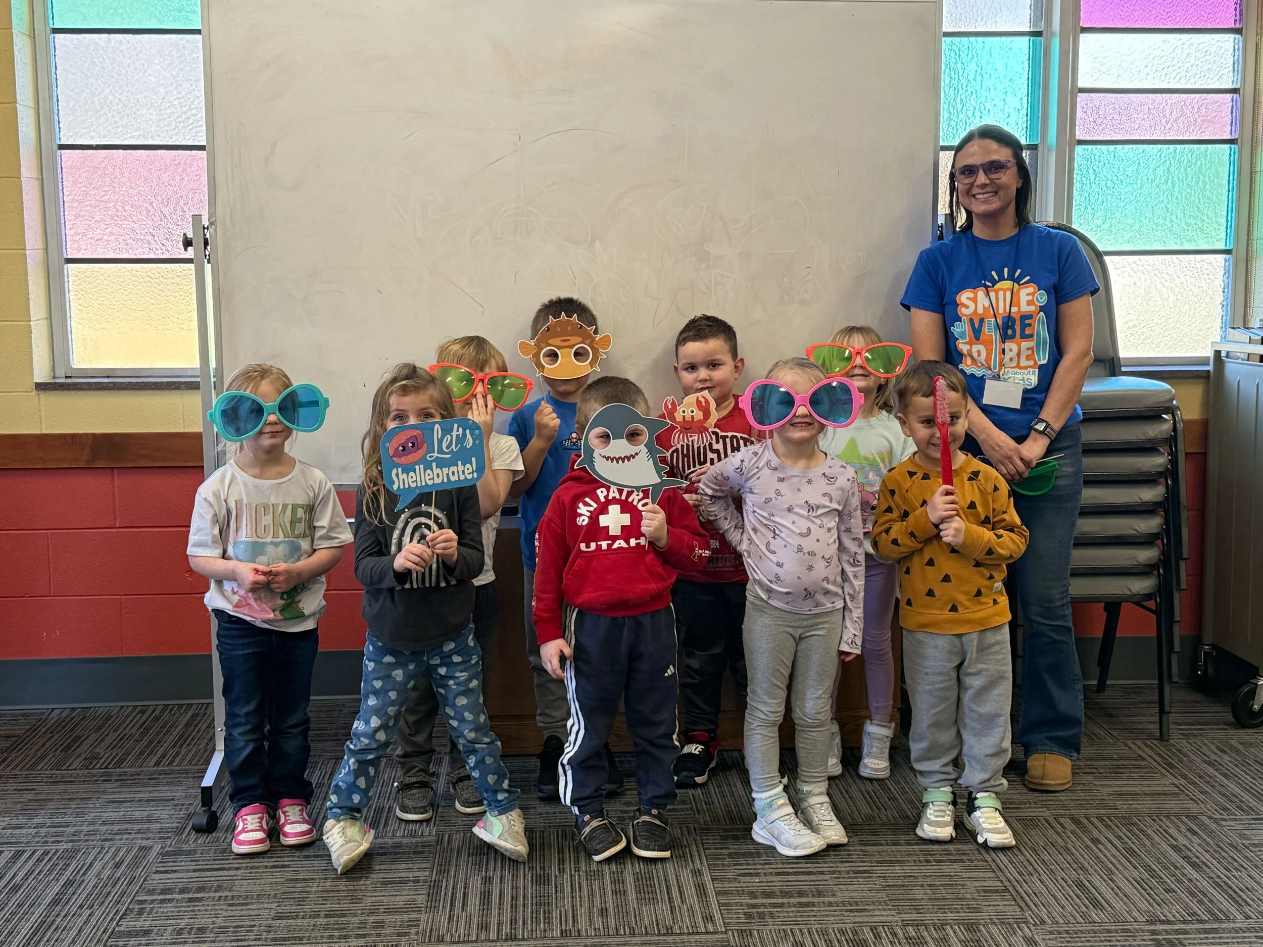 All About Kids Pediatric Dentistry team member and students celebrating National Children's Dental Health Month with fun photo booth props