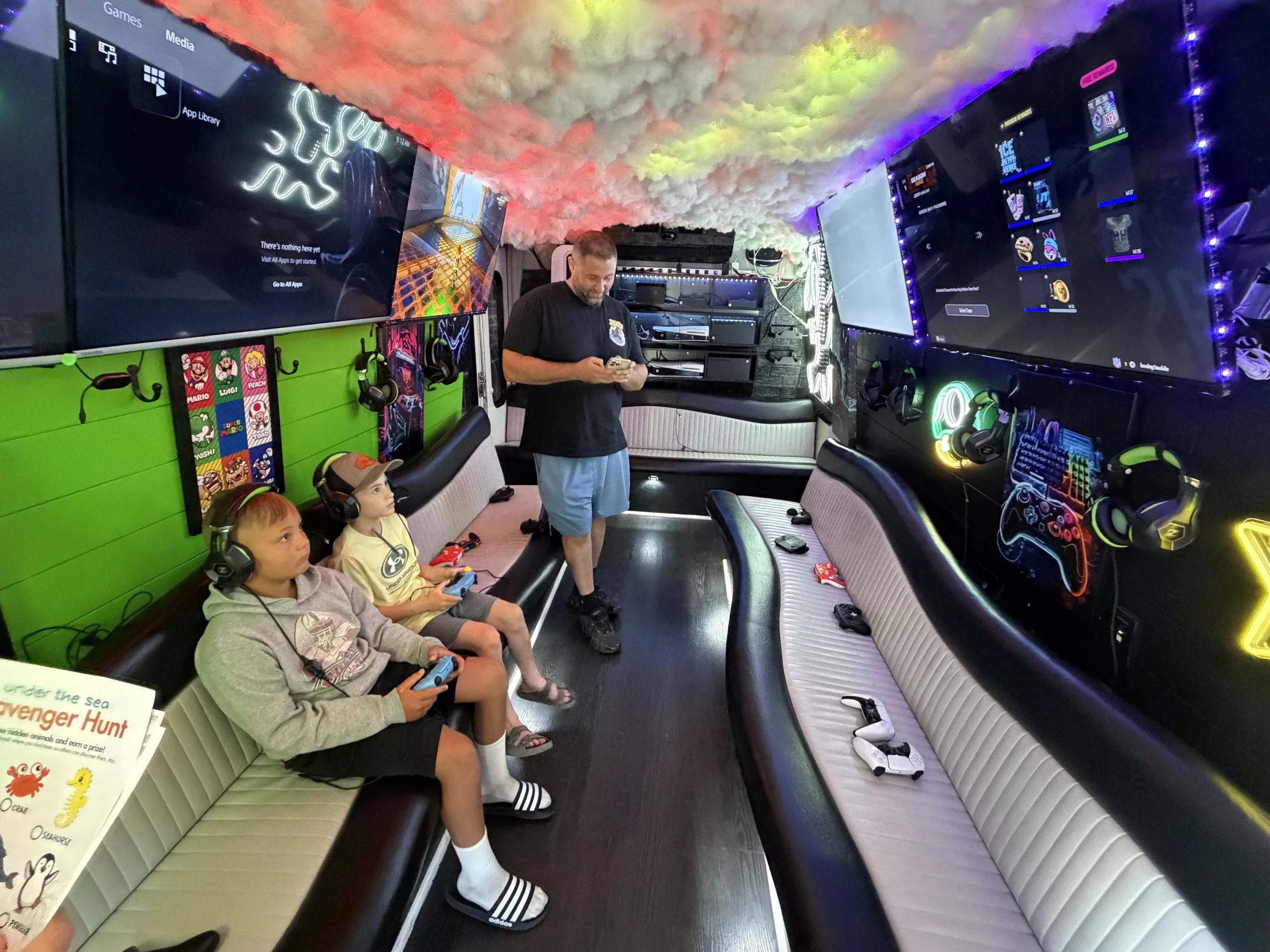 Kids playing video games inside the gaming truck during the All About Kids Pediatric Dentistry Family Fun Day.